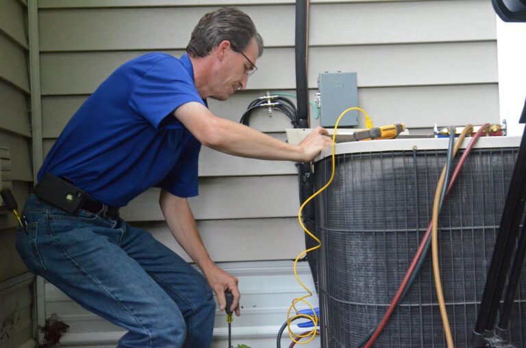 AC repair technician servicing air conditioner unit